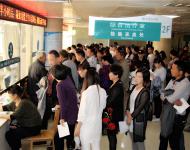 檢驗(yàn)科采血處排滿了前來檢查的患者，把過道堵得嚴(yán)嚴(yán)實(shí)實(shí)。