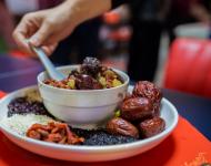 1月4日，內蒙古呼和浩特市玉泉區(qū)清泉街社區(qū)一位老人在展示臘八粥食材。當日，呼和浩特市玉泉區(qū)清泉街社區(qū)舉辦“溫暖臘八粥 濃濃鄰里情”活動，喜迎即將到來的“臘八節(jié)”。新華社發(fā) 丁根厚 攝