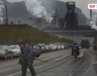 松汀村民毛溫秀，今年60歲，他背著籮筐，手拿鏟子去撿焦炭。他以此為生。