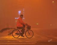 2017年1月4日早晨，一名環(huán)衛(wèi)工人在大霧中的安徽阜陽街頭騎行。盧啟建/視覺中國