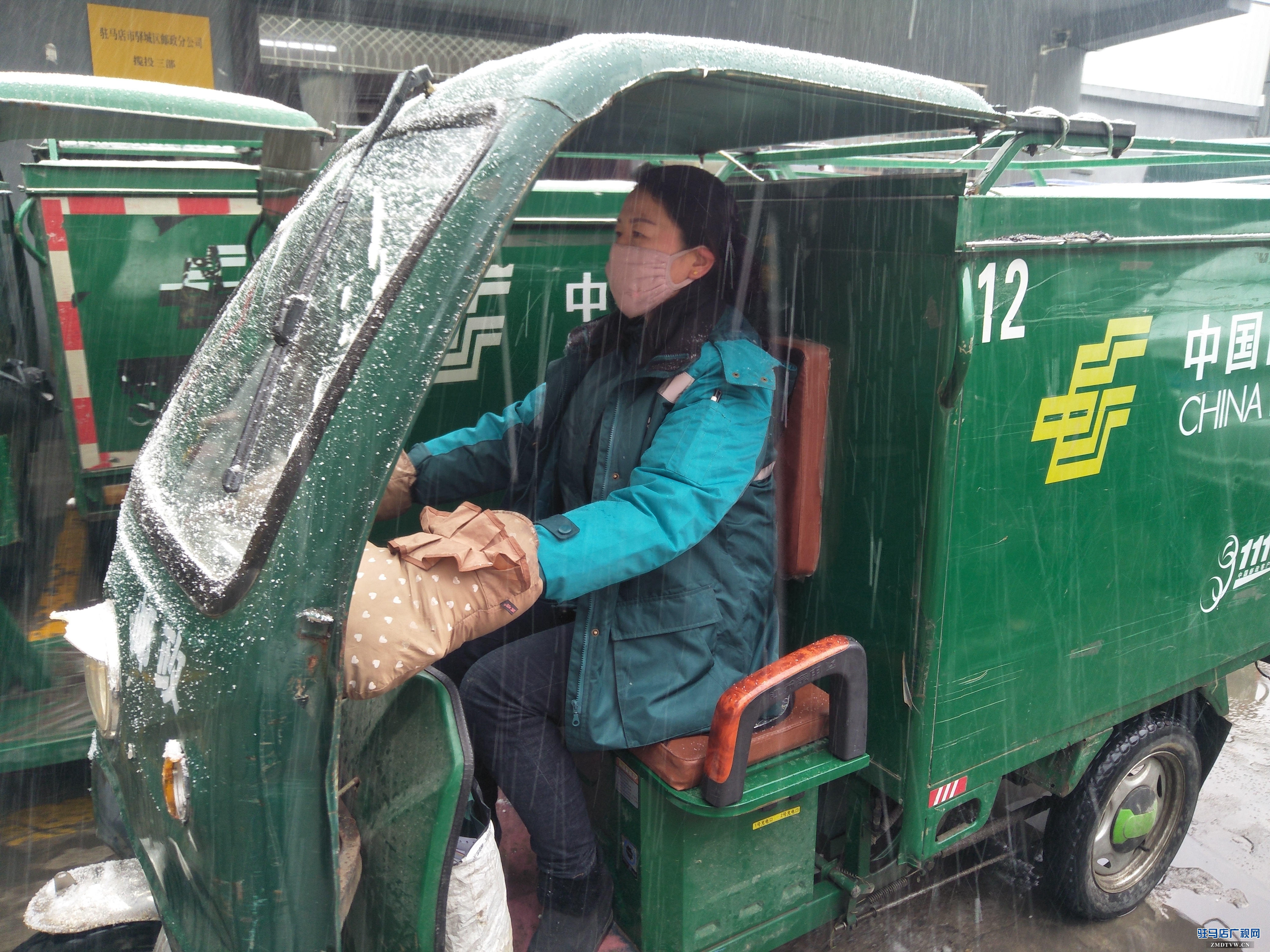 驛城區郵政分公司投遞員冒雪送郵件